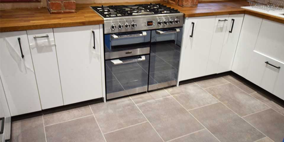 grey luxury vinyl tiles by Karndean design flooring installed into a mid size rustic kitchen.